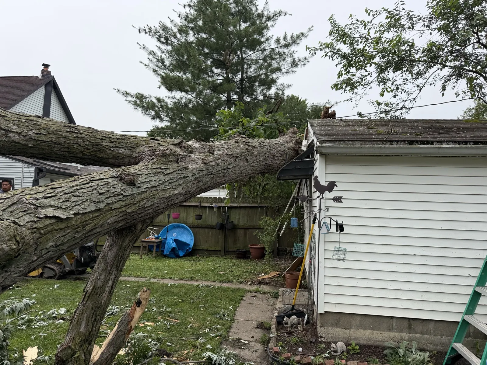 Storm-damaged oak fallen across a garage roof, awaiting cleanup by Cristobal Tree Services near Indianapolis